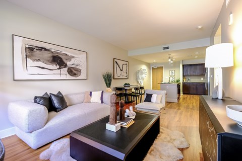 A modern living room with a white sofa and a black coffee table.